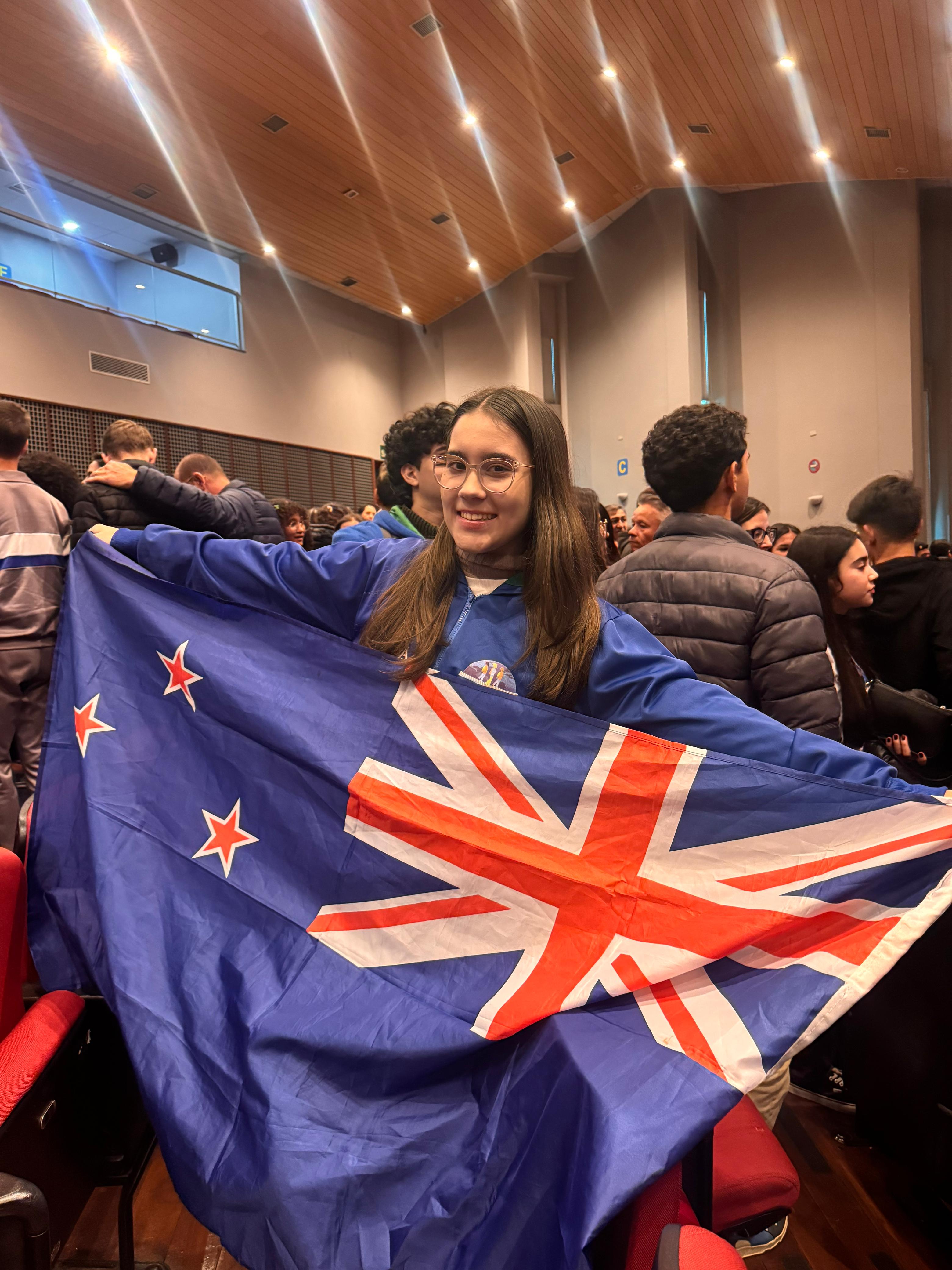 Imagem de Sibelly segurando a bandeira da Nova Zelândia